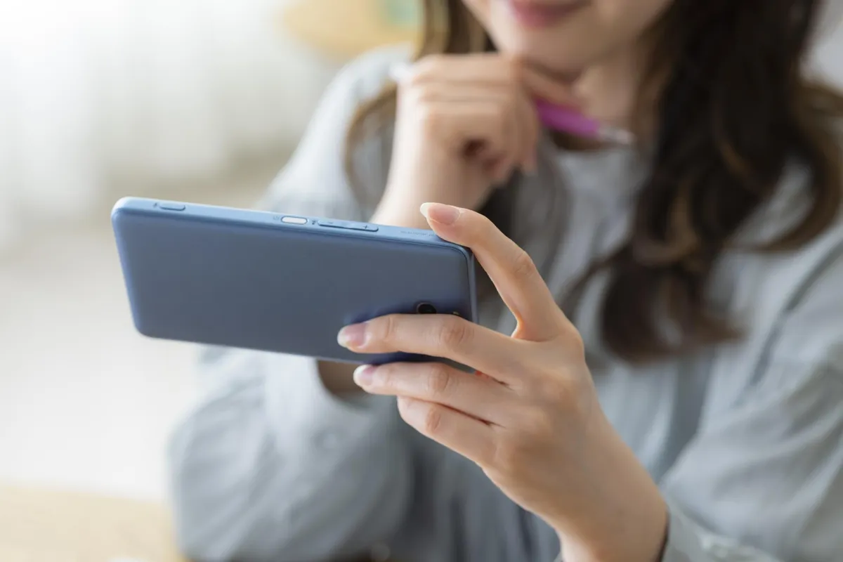 スマートフォンで物件情報を見る女性